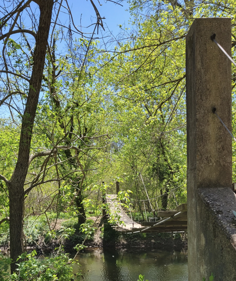 A small pedestrian bridge over a stream inside the Rogers Wildlife Refuge.